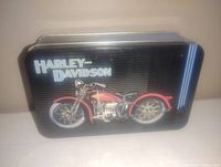 Metal rectangular tin with Harley-Davidson logo and vintage motorcycle illustration on lid.
