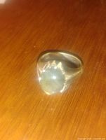 Labradorite ring placed on wooden surface showing the top view of the stone and setting.