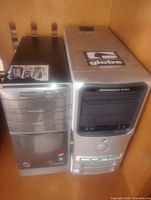 Two computer towers side by side on a wooden shelf, HP Pavilion on left and Dell Dimension 9150 on right.