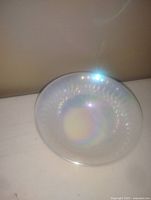 Top and slightly angled view of a vintage milk glass bowl showing iridescent lusterware finish and translucent white color.