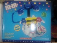 Box image showing M&M's retro clock radio phone with colorful branding and characters