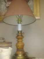 Photo of vintage collectible table lamp with wooden base and conical brown fabric lampshade.