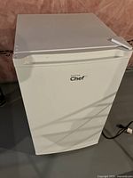 White mini bar fridge front view with closed door and visible Master Chef logo
