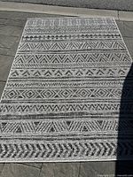 Full top view of the rectangular black and white mat showing the full pattern and condition.