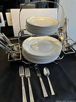 Buffet serving center holding stacked plates and displayed flatware in front.