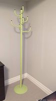 Full view of tall green metal coat stand showing overall size and base