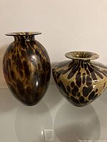 Both decorative glass vases shown side by side on a flat surface with clear view of their shapes and patterns.