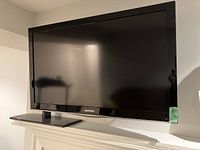 Front view of Samsung flat screen TV on stand, showing size and brand logo on bottom bezel.