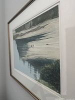 Framed watercolour painting showing coastal beach scene with two figures, water, cliffs, and vegetation.