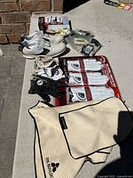 Photo showing golf shoes, gloves (new and used), golf towels, tees, and parts of golf balls packaging.