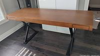 Full frontal view of desk showing veneer top and black metal X-frame legs