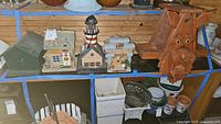 Shelf with five assorted wood birdhouses and some flower pots below