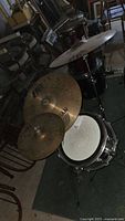 Overall view of cymbals and snare drum setup showing cymbals on stands and snare drum with head visible.
