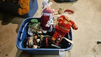 Photo of assorted Santa figurines in blue plastic tub showing various characters and styles in lot