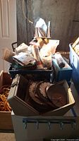 Wide view showing bins and containers with saw blades, hardware supplies, and other accessories in basement storage area.