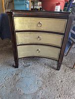 Front view of Bassett dresser showing three curved front drawers with metal ring pulls and dark wood frame.