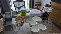 Photo of full kitchenware set on glass table including bread pans, bowls, trays, jello mold, blender parts
