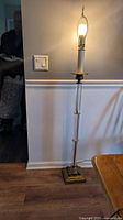 Full standing floor lamp showing length, base, and wall background for scale.