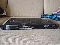 Front angled view showing 8 power outlet controller switches, outlet labels, and power cable connected at rear.