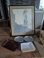 Photo showing all items: framed art print, two Wilton cake pans, purple Pyrex dish, yellow enamel dish.