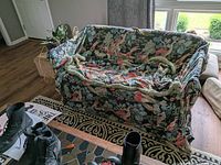 Sofa covered with vintage toile fabric featuring a floral design, showing overall fit and pattern.