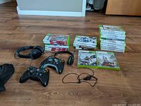 Overall view of games, controllers, and headphones on floor.