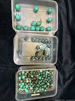 Three plastic containers with different beads and stones: large Amazonite beads, blue Jasper stones, small Ocean Jasper beads.