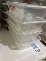 Clear flower-shaped crystal beads in stack of three plastic containers