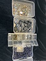 Overview of labradorite stones and bezel set cabochons in plastic boxes, with loose tumbled stones and faceted iolite beads included