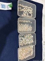 Four plastic containers showing all pearl groupings