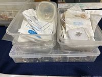 Top view of two clear plastic containers holding assorted silver jewellery components
