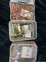 Three clear plastic containers filled with mixed tourmaline beads and small baggies