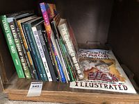 Books arranged on a wooden shelf, showing titles about Canadian landmarks, nature, and wildlife as well as gardening and historical exhibitions.