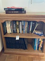 Shelf with a collection of hardcover books including Time Life war series and other titles, some stacked on top.