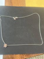 Full view of necklace on black background showing pendant and chain