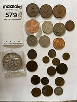 Overhead view of full lot laid on white background showing medal, copper round, large and small coins