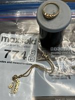 Photo showing the 10K gold bracelet with #1 sister pendant and 10K gold ring on a white stand.