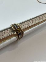 Ring on mandrel showing six colored synthetic stones in a row