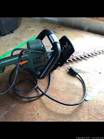 Black and green B&D electric hedge trimmer with an 18-inch blade, corded.