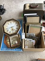 Box containing the clock and assorted picture frames including the octagonal clock with pendulum.