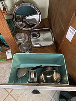 Kitchen items including metal trays, bread box, small bowls and cups, a grater and utensils