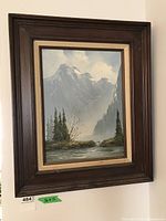 Full view of framed painting showing mountain landscape with river and trees.