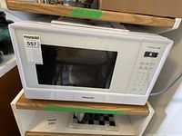 Panasonic microwave overall view showing the device with a white finish and standard design with a door window.