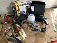 Wagner power painter kit with accessories, hand tools, hose, canister, and carrying case laid out on wooden table.