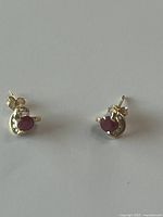 Pair of gold stud earrings with rubies and diamonds, front view
