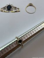 Front view on sizing mandrel showing oval sapphire center and diamond halo.