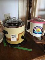 Wide view of the slow cooker with glass lid and the ice cream maker on adjacent surfaces.