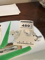 Photo showing two Swarovski crystal figurines, a duck and a bird, placed on a mirrored surface with a MaxSold auction label.