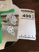 Two small clear crystal figures of a dog and a mouse placed on a round mirror base. The dog has frosted wings and both have black eyes and noses.