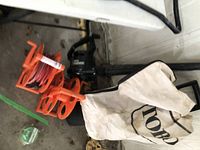 Toro electric Super Blower Vac with attached collection bag, orange extension cords coiled on reels.